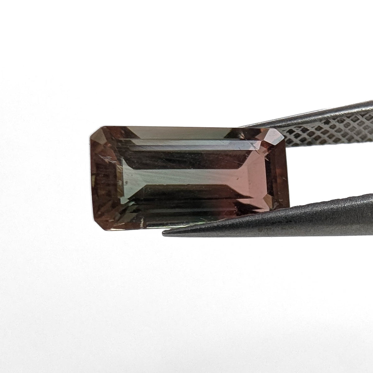 Oregon Sunstone faceted emerald cut gemstone, 2.39ct, from Plush, Oregon, held in tweezers, view 2 of 11