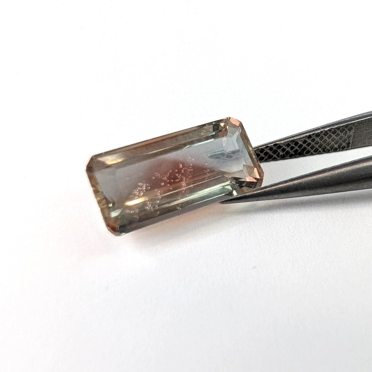 Oregon sunstone faceted emerald gemstone, 3.60ct, held in tweezers, view 2 of 7