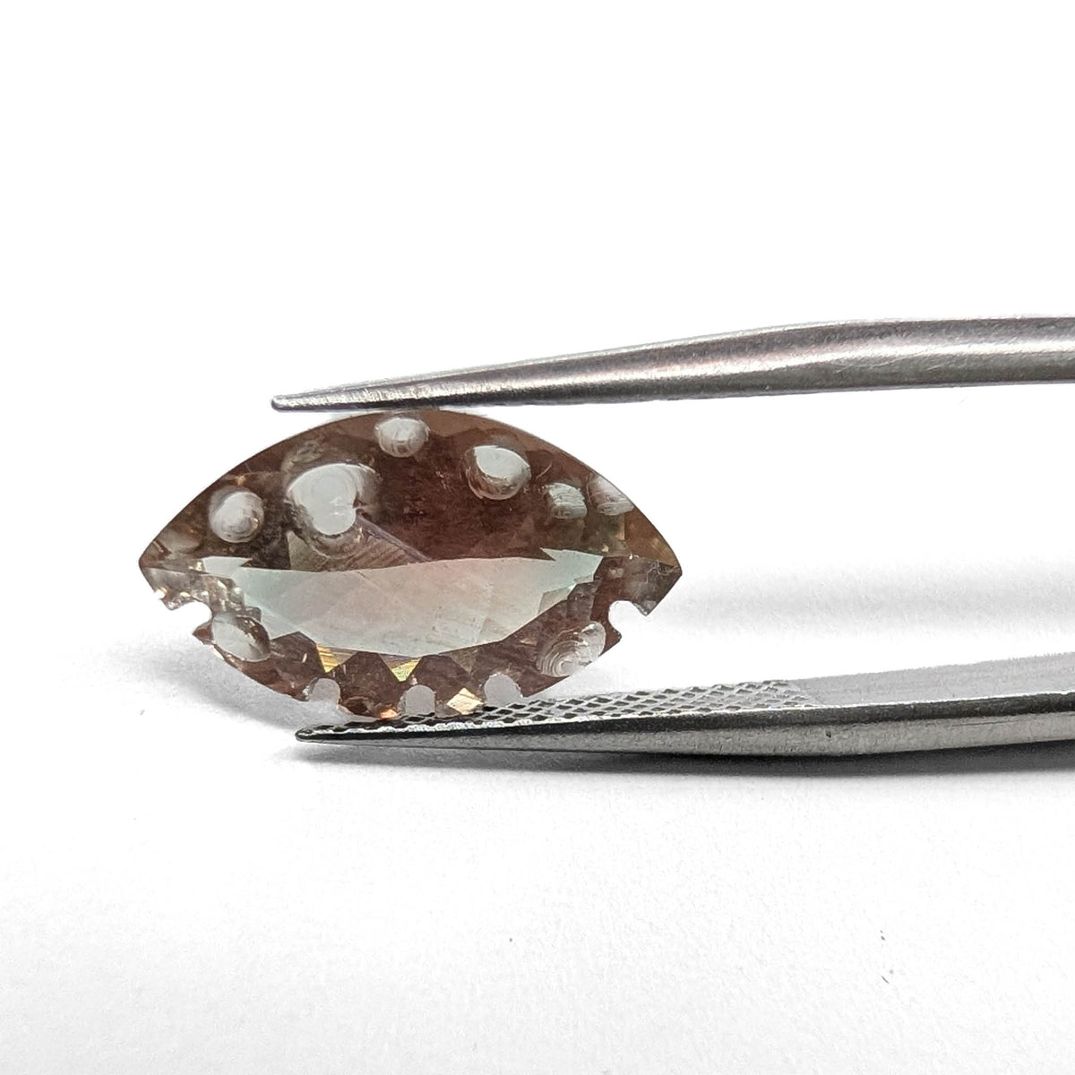 Oregon sunstone faceted marquise fantasy cut gemstone, 3.28ct, held in tweezers, view 9 of 11