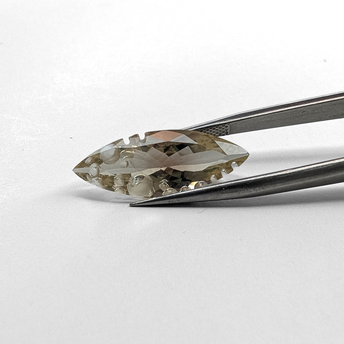 Oregon sunstone faceted marquise fantasy cut gemstone, 6.42ct, held in tweezers, view 9 of 9