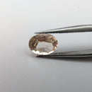 Oregon sunstone faceted oval gemstone, 1.70ct, held in tweezers