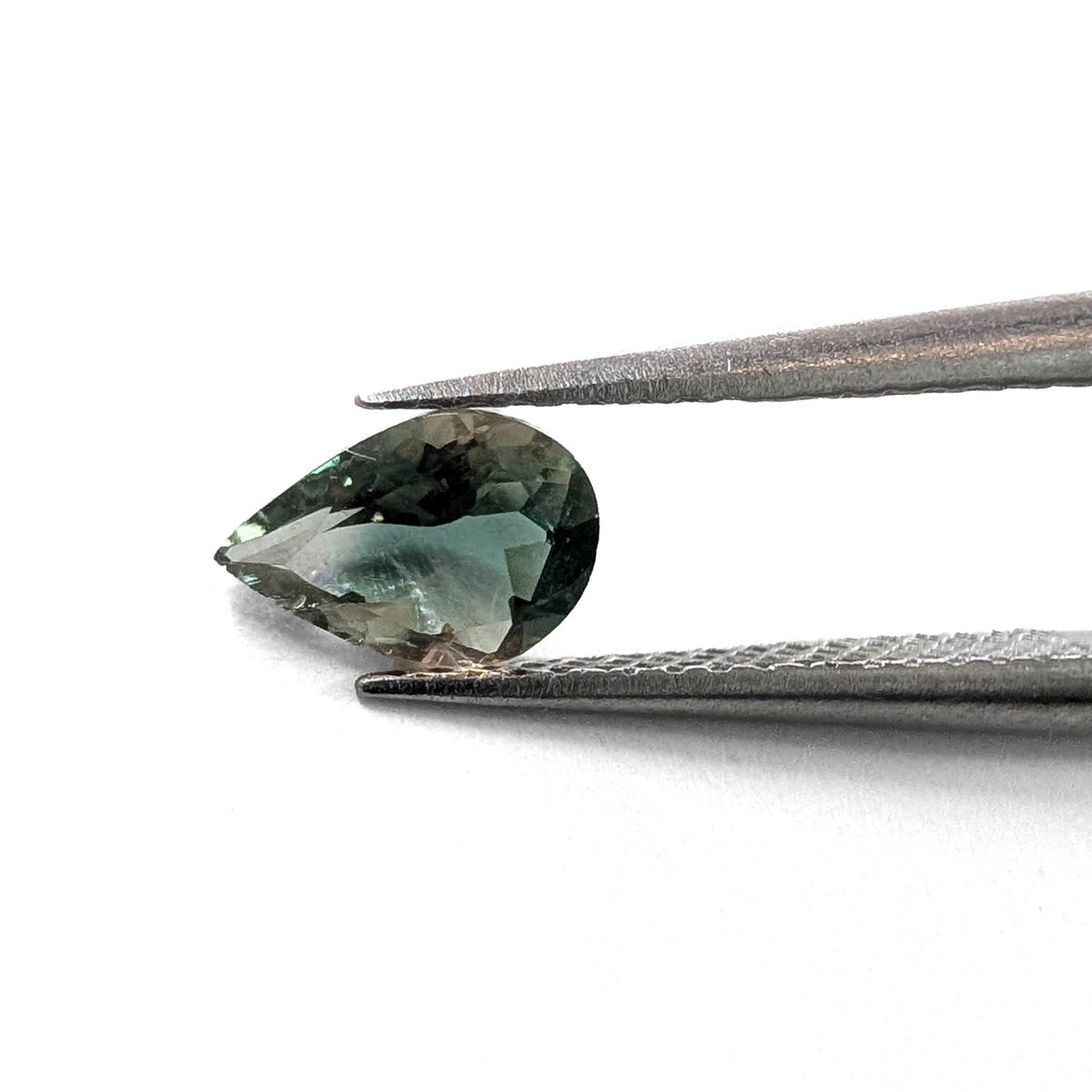 Oregon Sunstone faceted pear cut gemstone, 0.59ct, from Plush, Oregon, held in tweezers, view 2 of 8