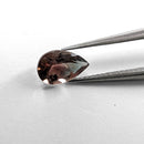 Oregon Sunstone faceted pear cut gemstone, 0.84ct, from Plush, Oregon, held in tweezers, view 2 of 9