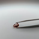 Oregon sunstone faceted pear gemstone, 1.32ct, held in tweezers