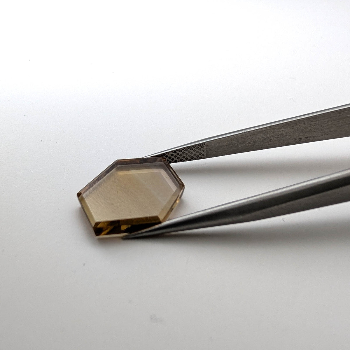 Smoky citrine faceted freeform flatback step cut gemstone, 5.35ct, from Brazil, held in tweezers, view 2 of 8