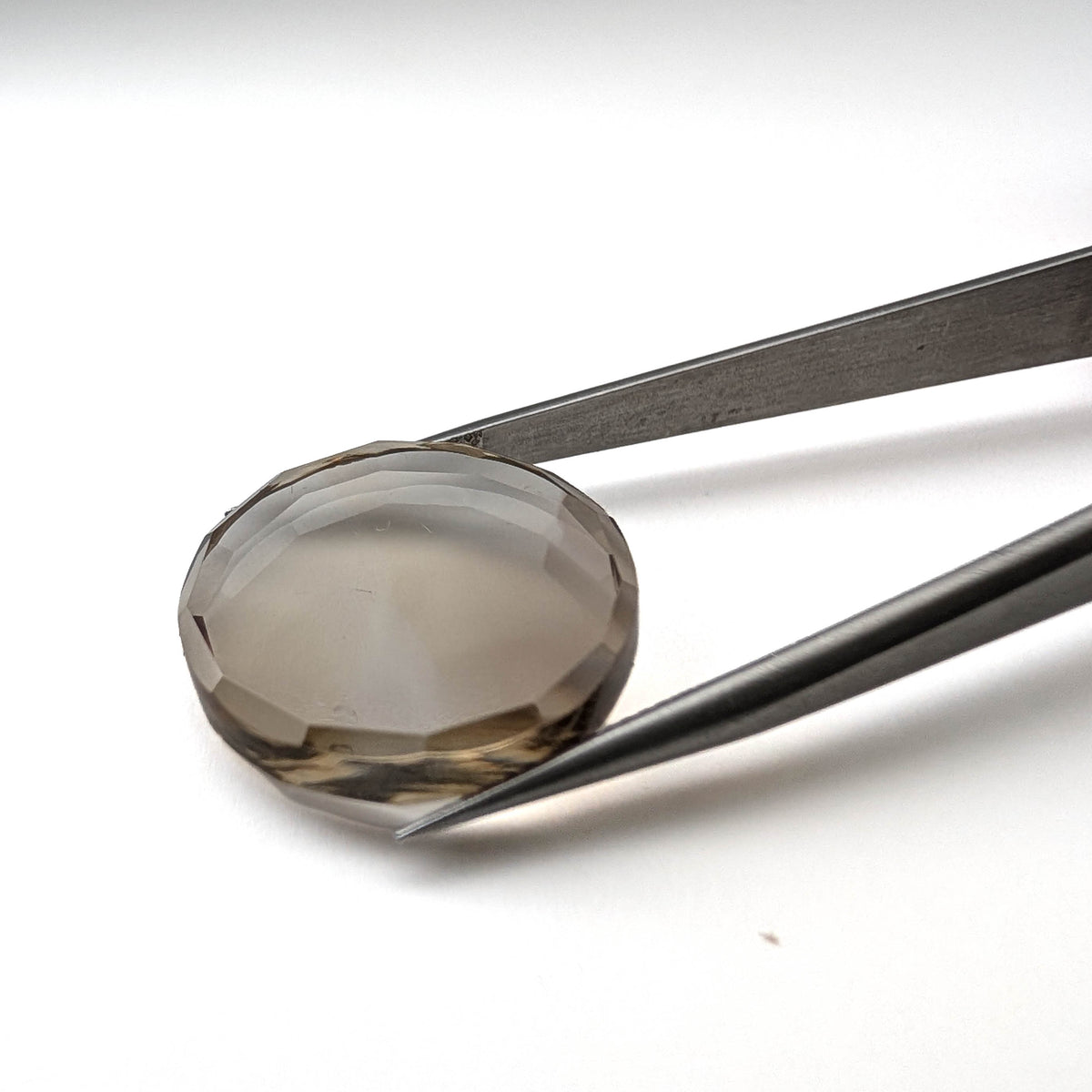 Smoky Quartz faceted round brilliant flatback gemstone, 21.80ct, from Minas Gerais, Brazil, held in tweezers, view 4 of 6