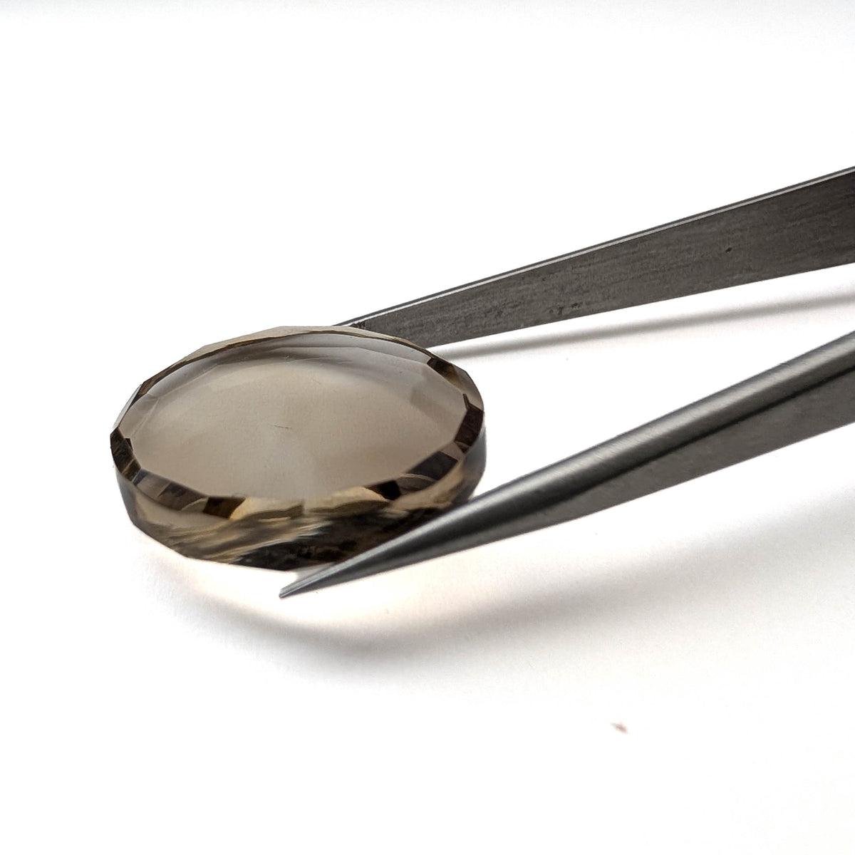 Smoky Quartz faceted round brilliant flatback gemstone, 21.80ct, from Minas Gerais, Brazil, held in tweezers, view 5 of 6