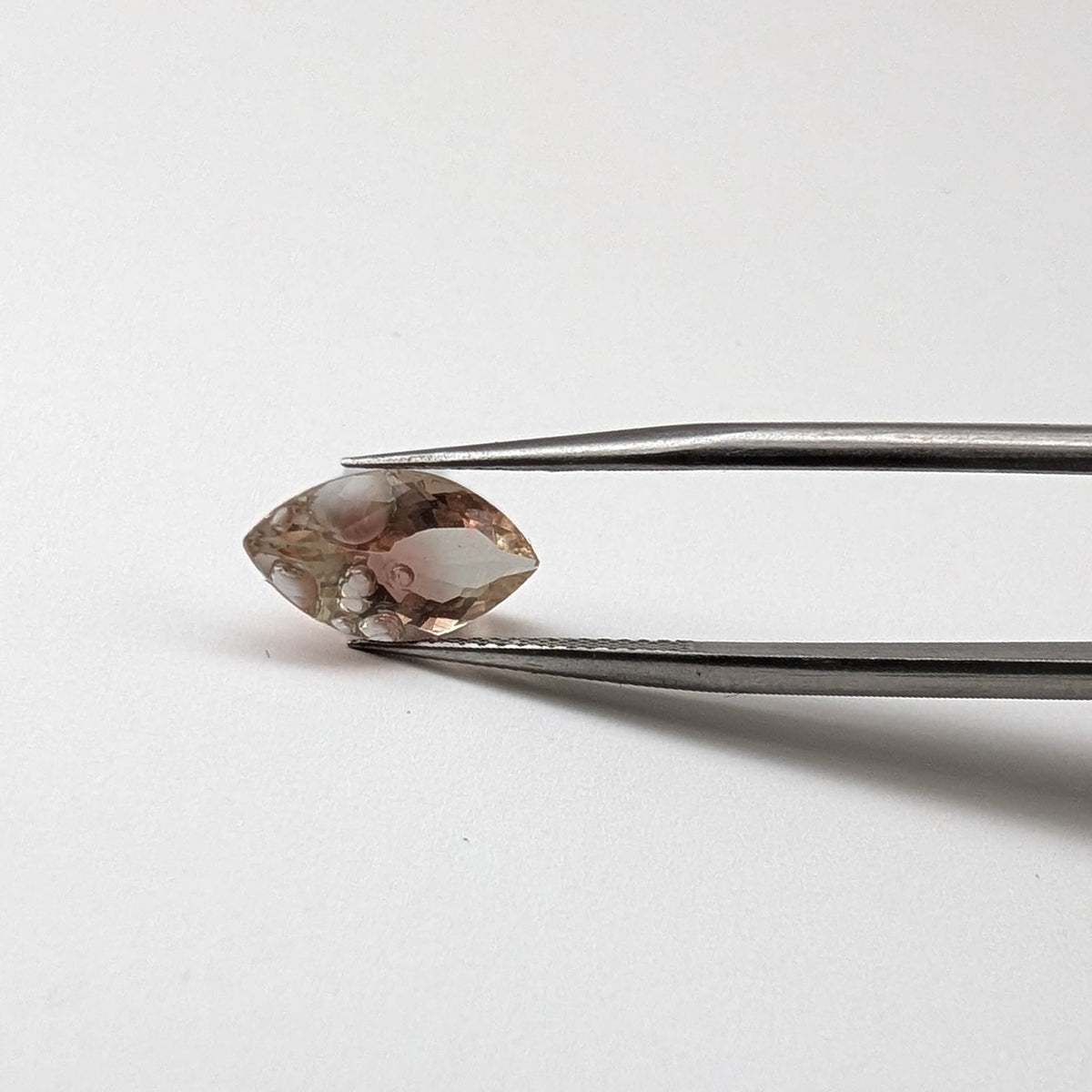Sunstone faceted marquise fantasy cut gemstone, 2.43ct, held in tweezers, view 10 of 12
