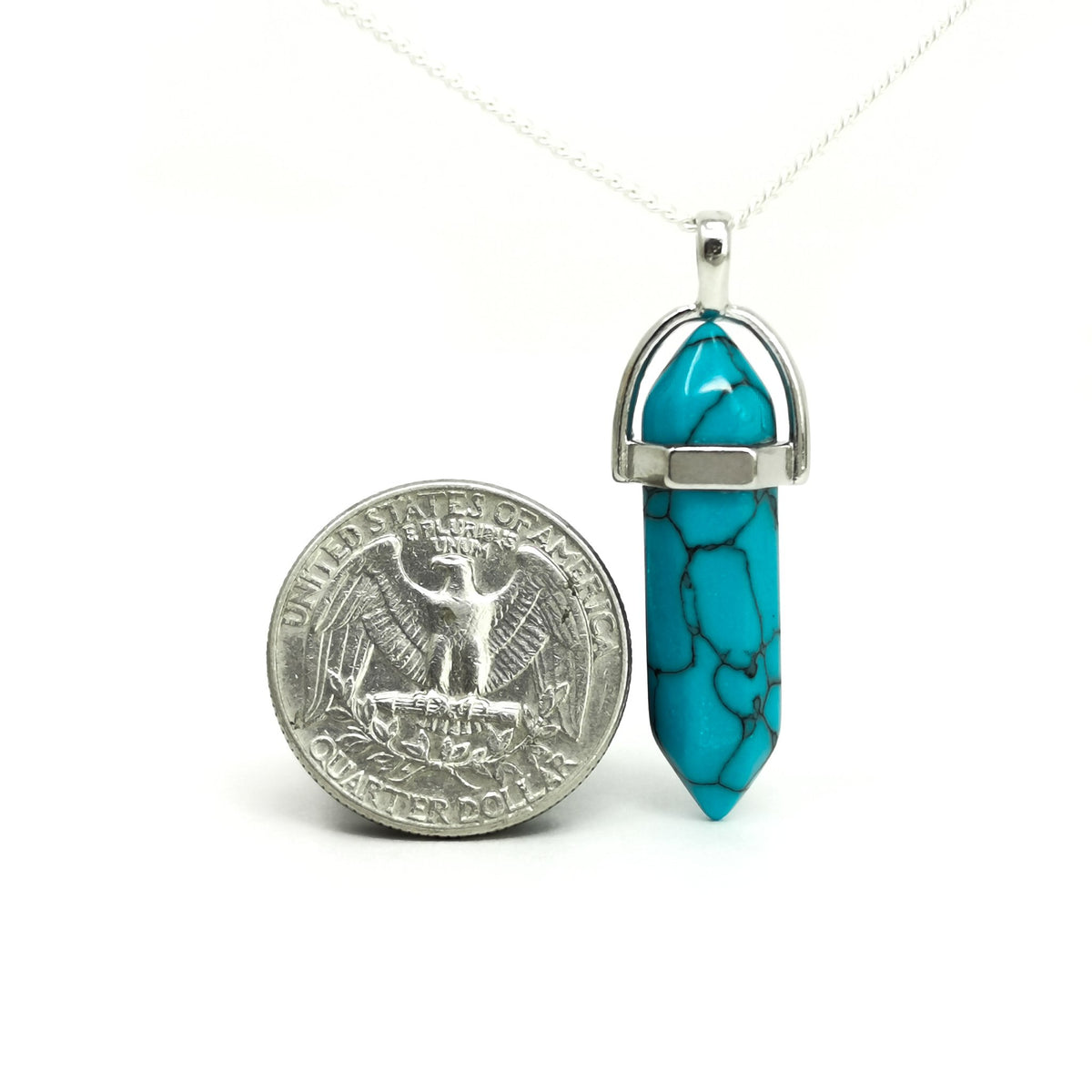 Double terminated crystal pendant: pendant beside a coin