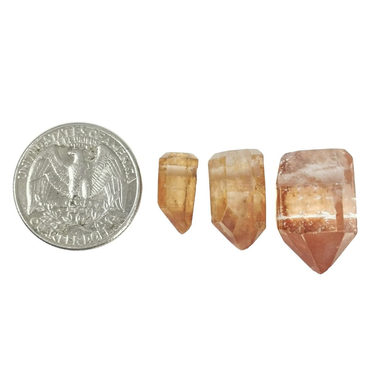 Mandarin quartz point pendant: pendant beside a coin